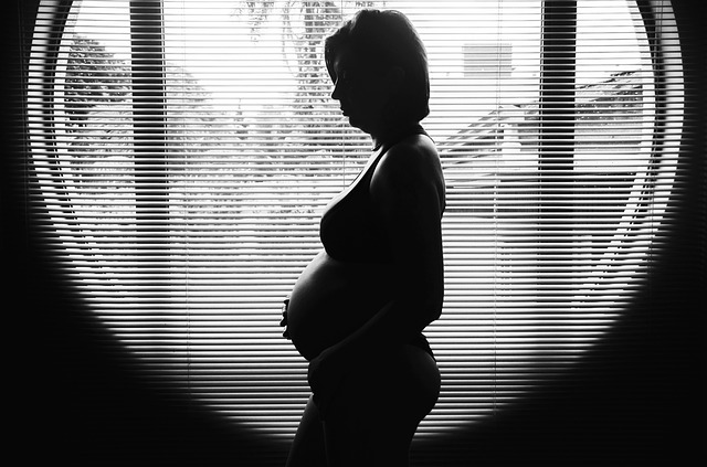 Silueta tehotnej ženy, ktorá stojí v okne.jpg